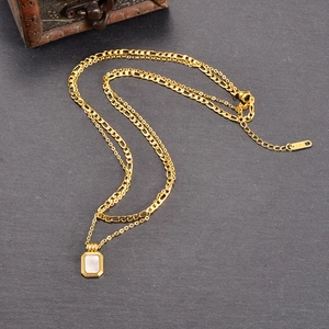 Double-layered gold necklace with Figaro chain and rectangular white mother-of-pearl pendant