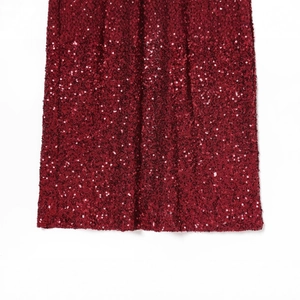 Luxurious burgundy sequin fabric detail of a V-neck dress with shiny reflective texture
