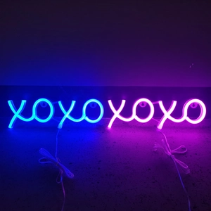 Detail showing blue and pink XOXO LED neon lights with clear wiring and wall mounts