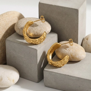 Textured C-shaped 18k gold plated stainless steel earrings on a minimalist stone base