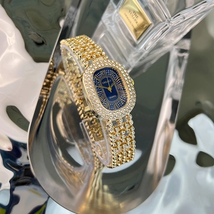 Close-up of luxury gold ladies watch with crystal inlay and deep blue oval dial