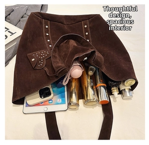 Detail view of deep brown suede tote bag showing rivet accents and large storage capacity