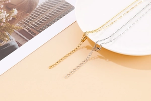 Close-up of gold and silver heart pendant necklace chains with lobster clasps and extenders
