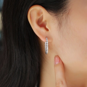 Elegant silver hoop earrings with double row moissanite shown on model ear for a modern look