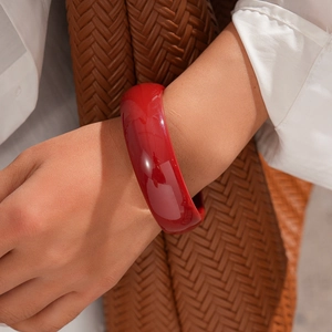 Detail of red resin wide cuff bracelet with polished finish and geometric chunky design
