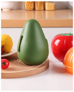 Detail of avocado and tomato shaped produce containers on a wooden cutting board