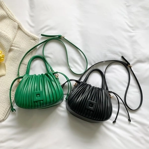 Detail view of stylish pleated bucket bags in green and black with matching straps