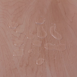 Macro shot showing waterproof water droplets on a transparent PVC tablecloth surface