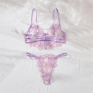 Flat lay of lilac floral embroidery lace lingerie set with mesh details on white fabric