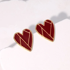 Boucles d'oreilles cœur rouge minimalistes avec plaqué or 18K sur marbre blanc