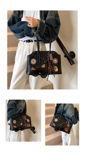 Détail du grand cabas noir rétro avec écussons brodés vintage et pendentifs de mode originaux
