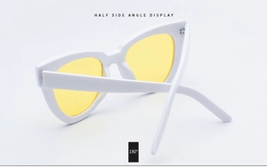 Half side angle view of white cat eye sunglasses with yellow lenses and metal hinges