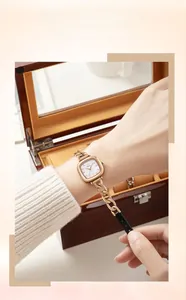 Détail de la montre carrée en or rose avec bracelet chaîne en métal et cuir au poignet