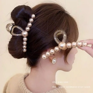 Detail of elegant pearl hair clip with rhinestones worn on a princess bun hairstyle