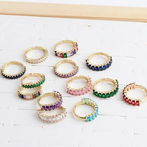 Adjustable gold rings with colorful rectangle zircon stones on a white textured background