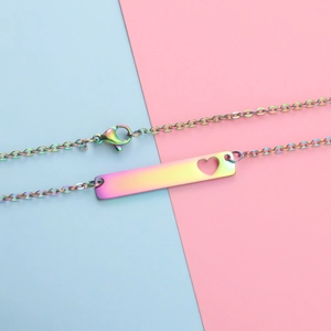 Macro detail of rainbow plated bar pendant with hollow heart on colorful background