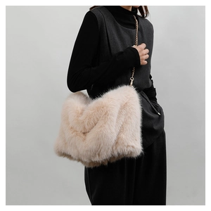 Close-up of beige plush tote bag featuring soft faux fur texture and gold chain strap
