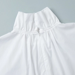 Close-up of elegant pleated stand-up collar and hidden zipper on white shirt