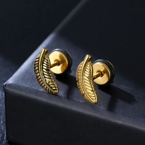 Punk style 316L golden feather stud earrings presented on a black textured gift box