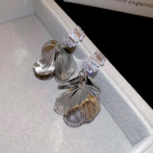 Exaggerated silver petal drop earrings with sparkling zircon stones in a jewelry box