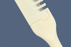Close-up of the beige dual-ended nose hair trimmer head with sharp metal blades