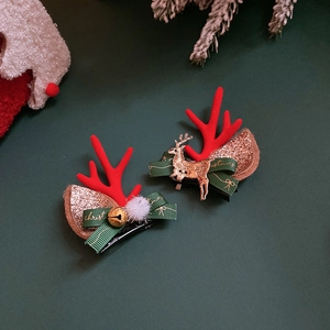 Close-up of festive Christmas reindeer hair clips with red antlers and gold bells