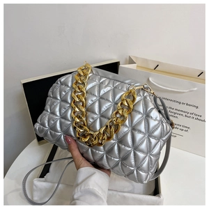 Detail of silver quilted shell bag featuring a thick gold chain and smooth PU leather finish