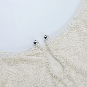 Close-up of off-white lace neckline featuring U-shaped cutout and silver metal bead detail