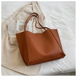 Close-up of a caramel brown large capacity tote bag with refined matte synthetic leather