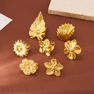 7-piece gold titanium steel ring set featuring floral and shell motifs on warm background