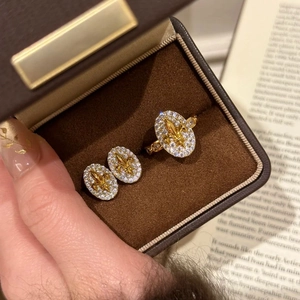 Detailed view of 18k gold plated oval fleur-de-lis jewelry set with white zircons