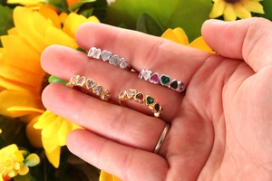 Detail view of gold and silver heart-shaped eternity rings with colorful zircon gems