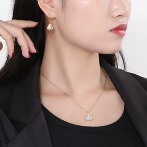 Detail of gold triangle crystal necklace and earrings set worn by a model