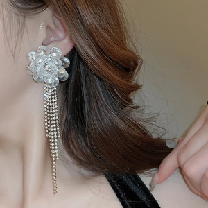 Detail der Blumen-Kristallohrringe mit langen, funkelnden Diamantquasten am Model