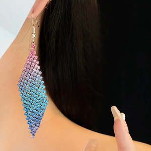 Gros plan sur des boucles d'oreilles losange en strass colorés avec franges dégradées