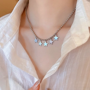 Close-up of silver five-point star pendant necklace on a delicate beaded chain