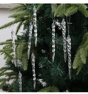 Detailed view of transparent spiral icicle ornaments hanging on a green Christmas tree