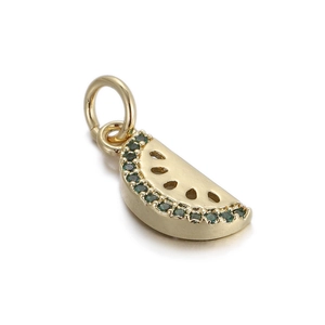 Detail of 14k gold plated watermelon charm with green gemstones and hollowed seeds