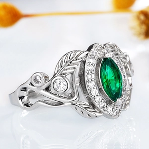Macro shot of marquise-cut green zircon ring with silver leaf design and pavé details
