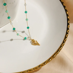 Collier tulipe minimaliste avec perles vertes et blanches sur fond de satin soyeux