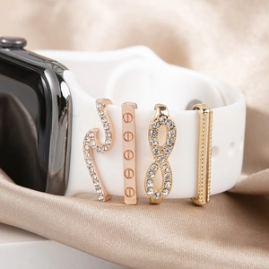 Golden Apple Watch band charms set with rhinestones on soft silk background