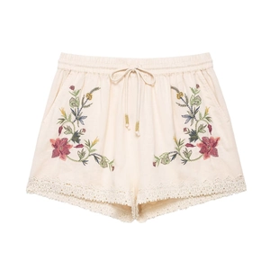 Women's cream knit shorts with floral embroidery, drawstring waist, and lace hem detail