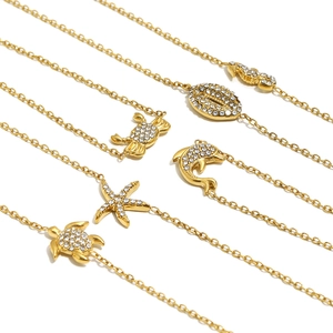 Detail of 18K gold-plated ocean-themed charms including turtle and starfish with zircons