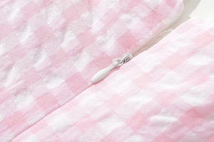 Macro shot of pink and white plaid fabric texture with a white invisible zipper detail