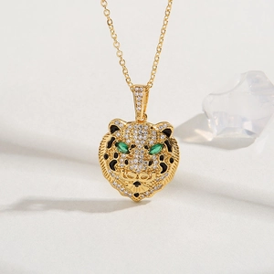 Macro detail of 18K gold plated brass leopard pendant with sparkling zircon and green eyes
