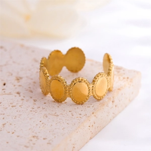 Vintage gold oval beaded open ring in titanium steel on a stone texture background