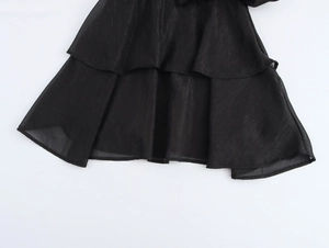 Vue macro détaillée de l'ourlet à volants double couche sur une robe en mousseline noire