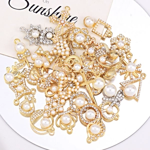 Mix of gold and silver DIY jewelry pendants with pearls and zircon on a round mirror tray