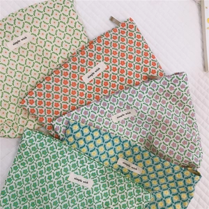 Close-up of five floral cotton cosmetic bags with zippers and simple wish labels
