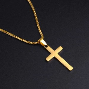 Detailed view of a gold double-layer cross pendant necklace on a dark textured background